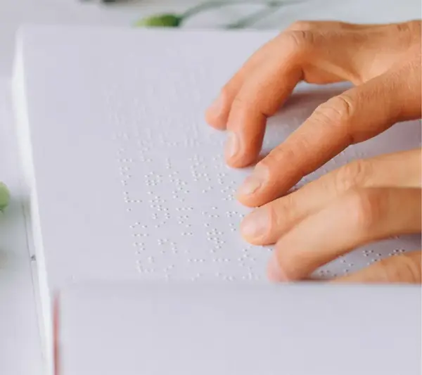 A close up of a braille book being read